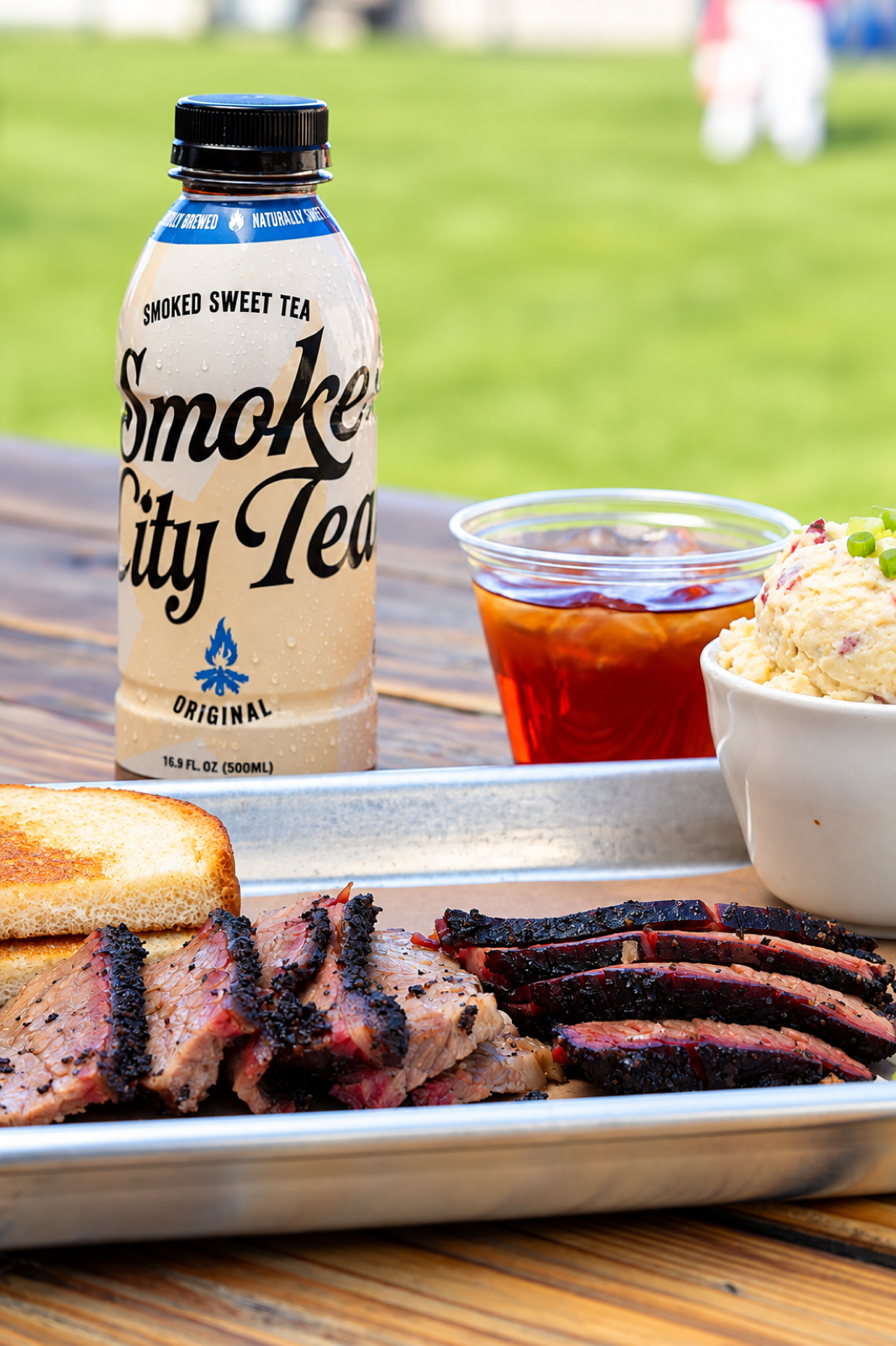 Smoke City Tea Original with sliced brisket on a picnic table